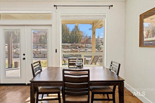 dining room with wood finished floors, baseboards, and french doors