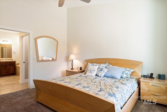 bedroom featuring light colored carpet, ensuite bath, a ceiling fan, and a sink