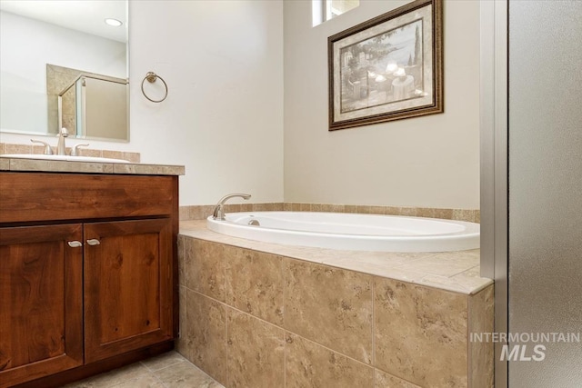 full bath featuring tile patterned floors, a garden tub, a stall shower, and vanity