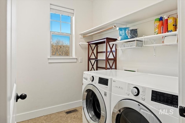 washroom with laundry area, separate washer and dryer, visible vents, and baseboards