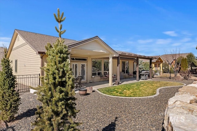 rear view of house featuring french doors, a patio, roof with shingles, and fence