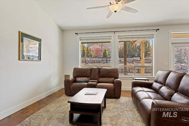 living room with wood finished floors, baseboards, and ceiling fan