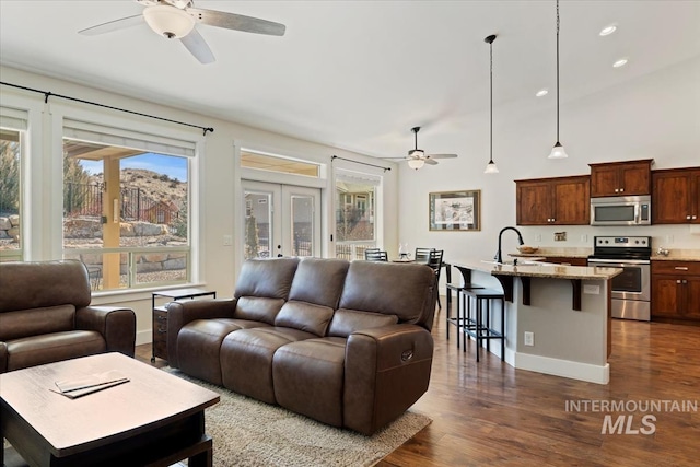 living area featuring french doors, baseboards, dark wood finished floors, and a ceiling fan