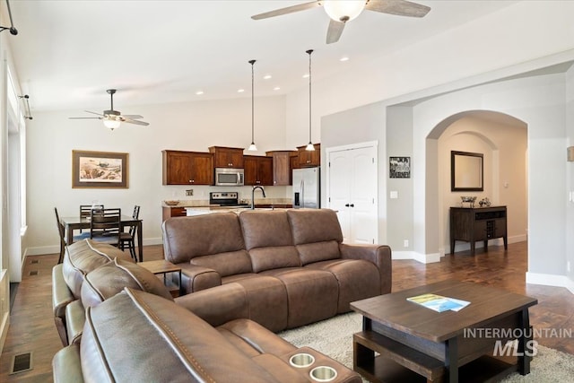 living area with a ceiling fan, recessed lighting, arched walkways, and visible vents