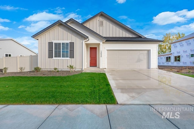 view of front of property with driveway, a front lawn, board and batten siding, and fence