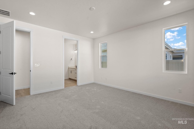 unfurnished bedroom with light colored carpet, visible vents, baseboards, and recessed lighting