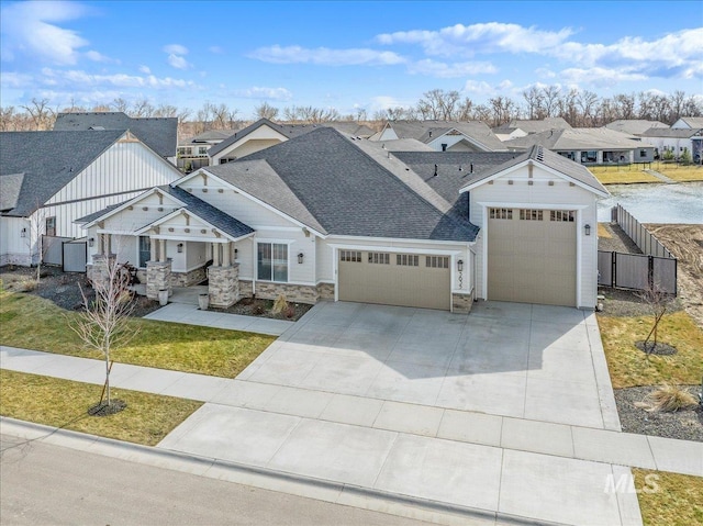 view of front of home with a garage, fence, stone siding, concrete driveway, and a residential view