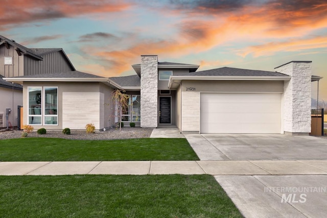 prairie-style home with a yard and a garage