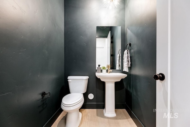 bathroom featuring wood-type flooring, toilet, and sink