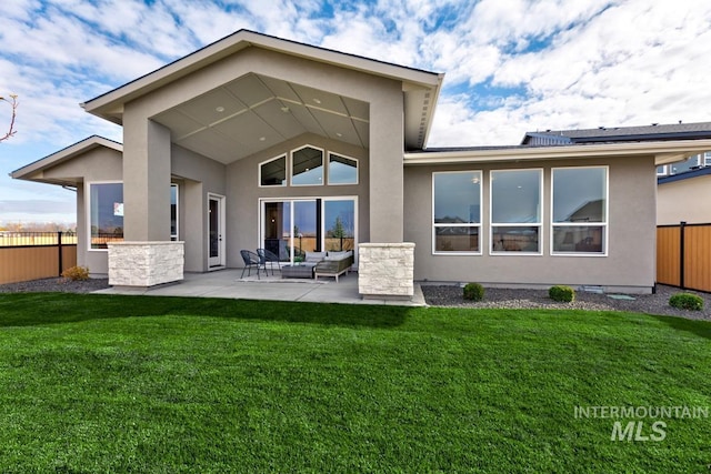 rear view of house featuring a lawn, an outdoor living space, and a patio