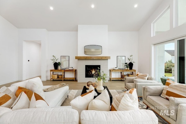 living room with a tile fireplace and light wood-type flooring