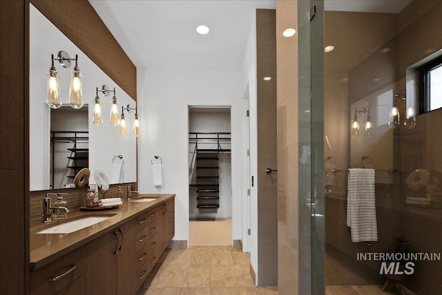 bathroom featuring a shower stall, a spacious closet, backsplash, double vanity, and recessed lighting