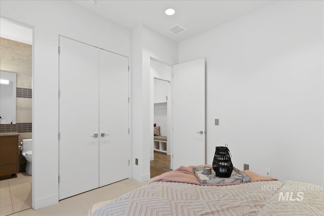 bedroom featuring a closet and ensuite bath