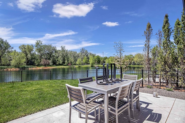 view of patio with outdoor dining space, a water view, and view of scattered trees