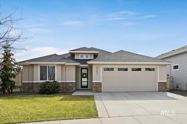 prairie-style home featuring stone siding, an attached garage, driveway, and a front yard