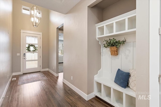 mudroom featuring a notable chandelier, visible vents, baseboards, and wood finished floors