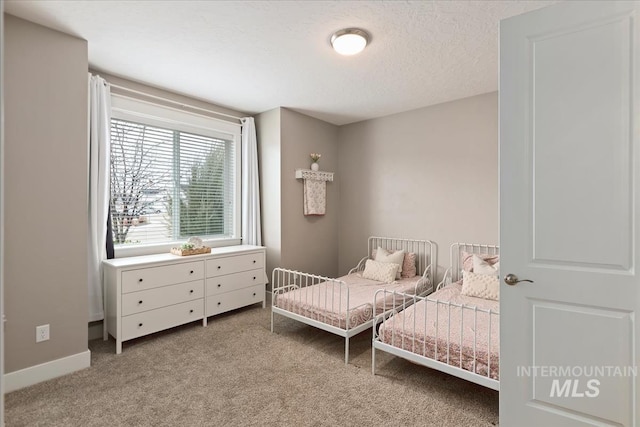 bedroom featuring a textured ceiling, baseboards, and light carpet