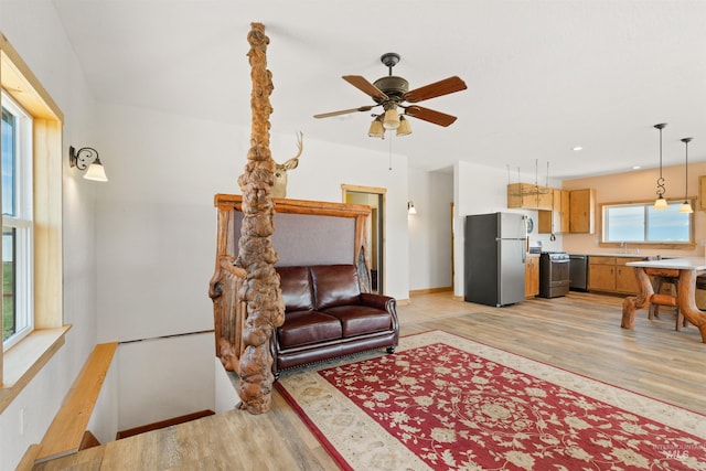 living room featuring ceiling fan and light wood-type flooring