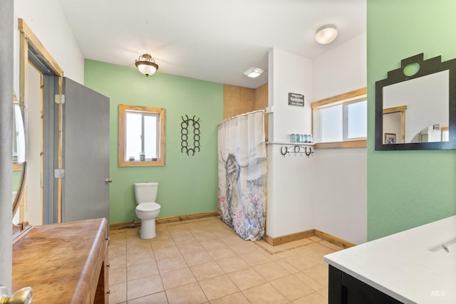 bathroom with tile flooring, vanity, and toilet