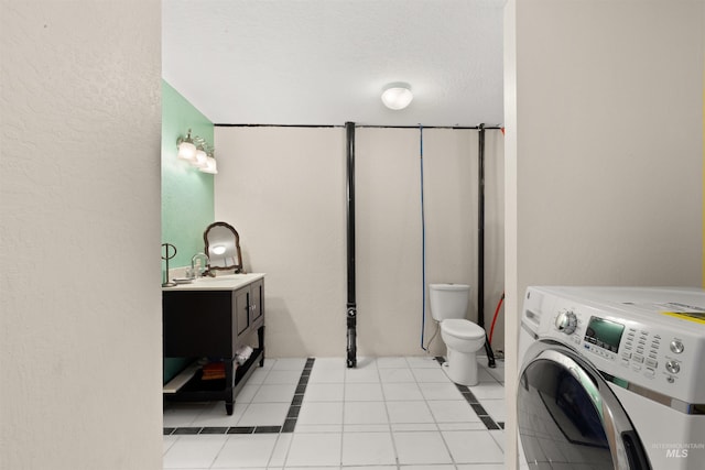 laundry area featuring sink, light tile flooring, and washer / clothes dryer