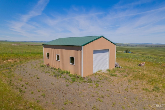 exterior space featuring a garage and a rural view