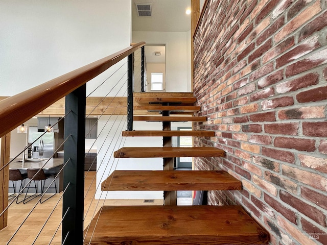 stairs with brick wall and tile patterned flooring