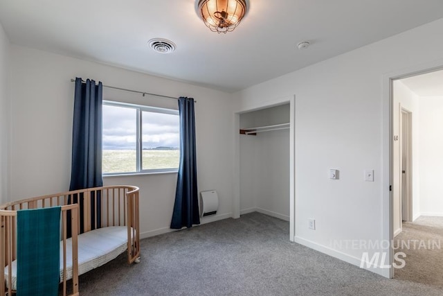 carpeted bedroom featuring baseboards and a closet