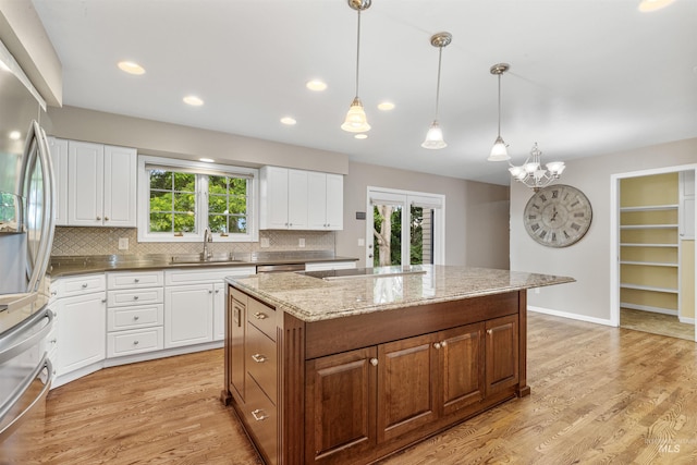 2220 14th St, Lewiston, ID 83501 - kitchen featuring freestanding refrigerator, a sink, a kitchen island, tasteful backsplash, and white cabinets