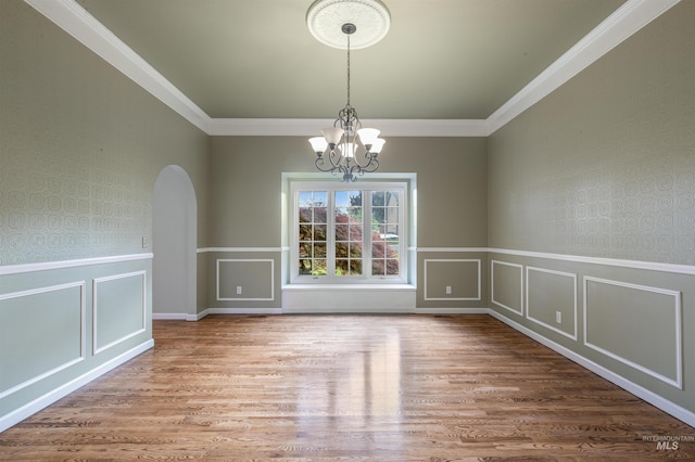 2220 14th St, Lewiston, ID 83501 - spare room featuring arched walkways, a chandelier, wood finished floors, crown molding, and a decorative wall