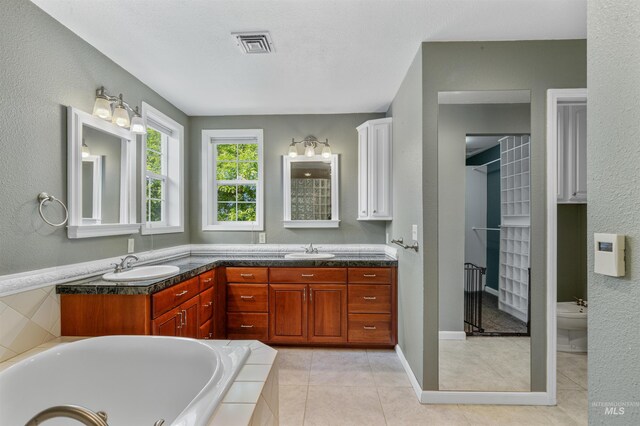 2220 14th St, Lewiston, ID 83501 - full bath featuring tile patterned floors, double vanity, tiled tub, a textured wall, and a bidet