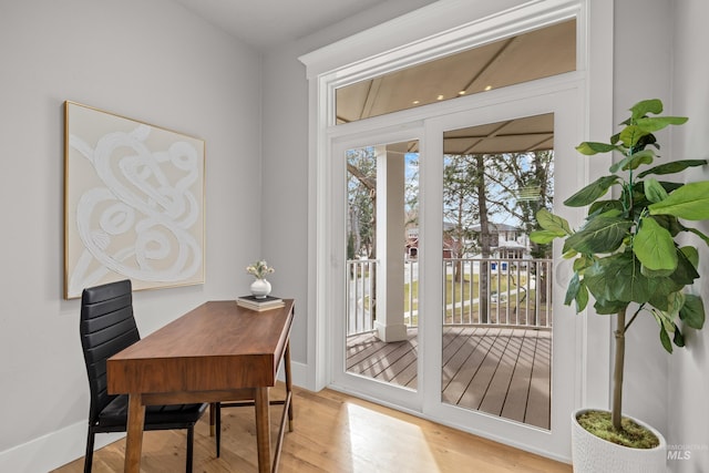 doorway with baseboards and wood finished floors