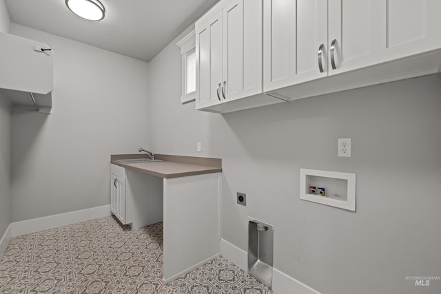 clothes washing area with cabinet space, baseboards, hookup for a washing machine, hookup for an electric dryer, and a sink