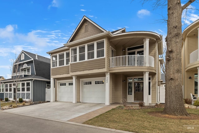 view of front of house featuring a garage, driveway, and a balcony