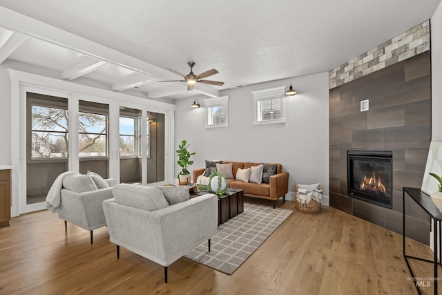 living area with a wealth of natural light, a fireplace, and wood finished floors