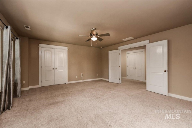 unfurnished bedroom featuring ceiling fan and light carpet