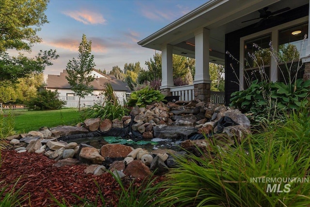 yard at dusk featuring a porch