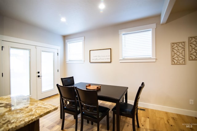 dining space with light hardwood / wood-style floors and french doors