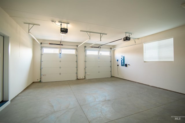 garage with a garage door opener and electric panel