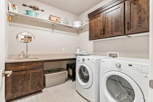 laundry room featuring cabinets, washer and dryer, and sink