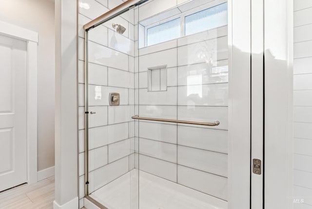 bathroom featuring an enclosed shower and hardwood / wood-style flooring