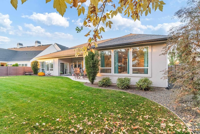 back of property with a patio area and a lawn