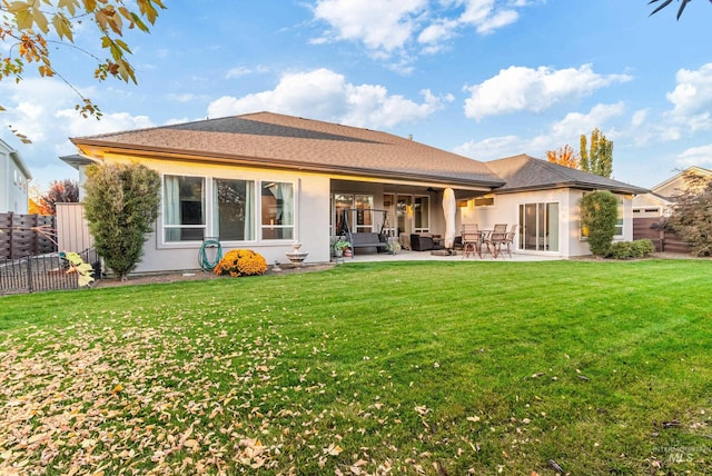 rear view of house with a yard and a patio area