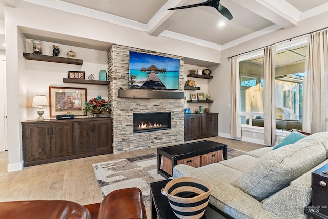 living room with beamed ceiling, light hardwood / wood-style flooring, a fireplace, and ceiling fan