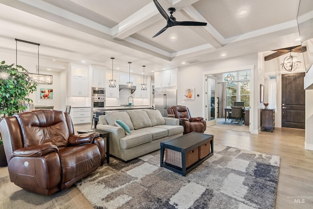 living room featuring beamed ceiling, sink, ceiling fan with notable chandelier, and hardwood / wood-style floors