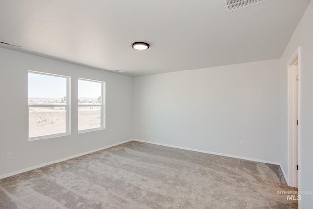 unfurnished room featuring light carpet