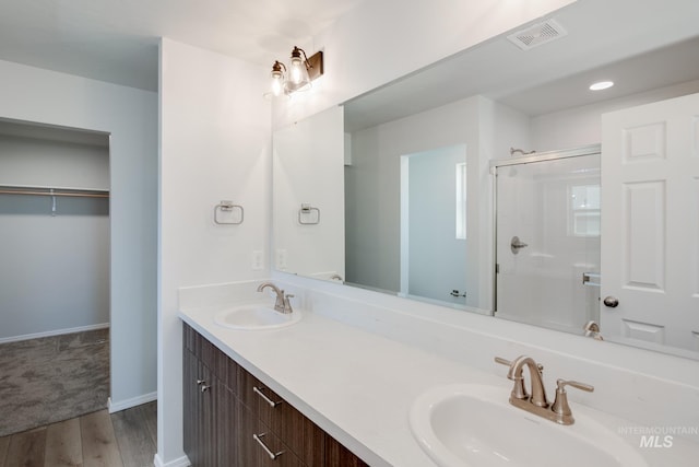 bathroom featuring hardwood / wood-style flooring, vanity, and walk in shower