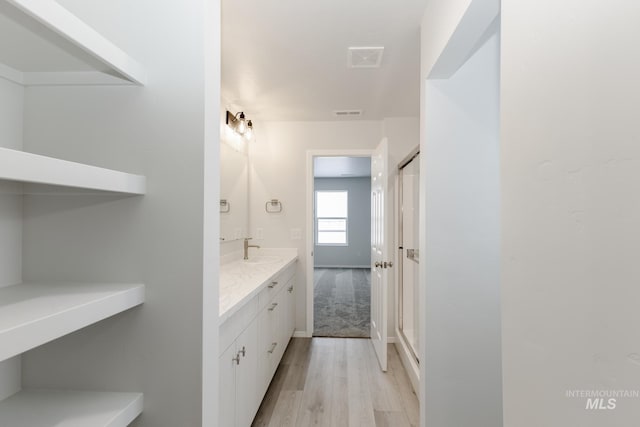 bathroom featuring vanity, hardwood / wood-style flooring, and an enclosed shower