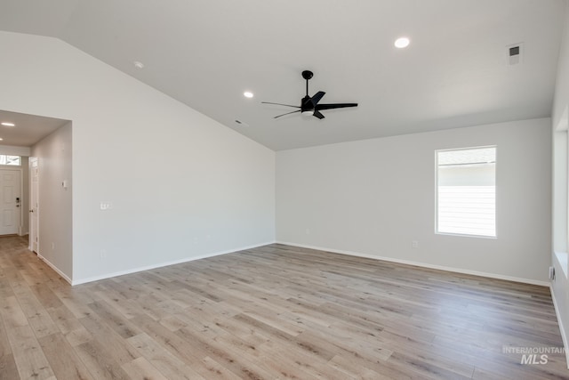 spare room featuring light hardwood / wood-style floors, vaulted ceiling, and ceiling fan