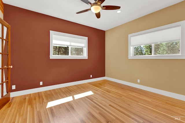 empty room with ceiling fan and light hardwood / wood-style flooring