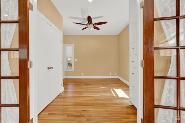 empty room with ceiling fan and light hardwood / wood-style flooring